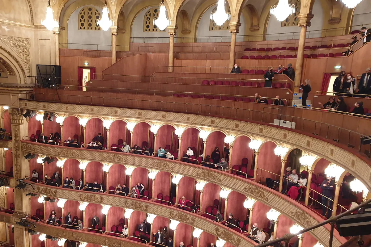 Řady červenozlatých lóží pod lustry v Teatro Costanzi, hlavním sále římského operního domu.